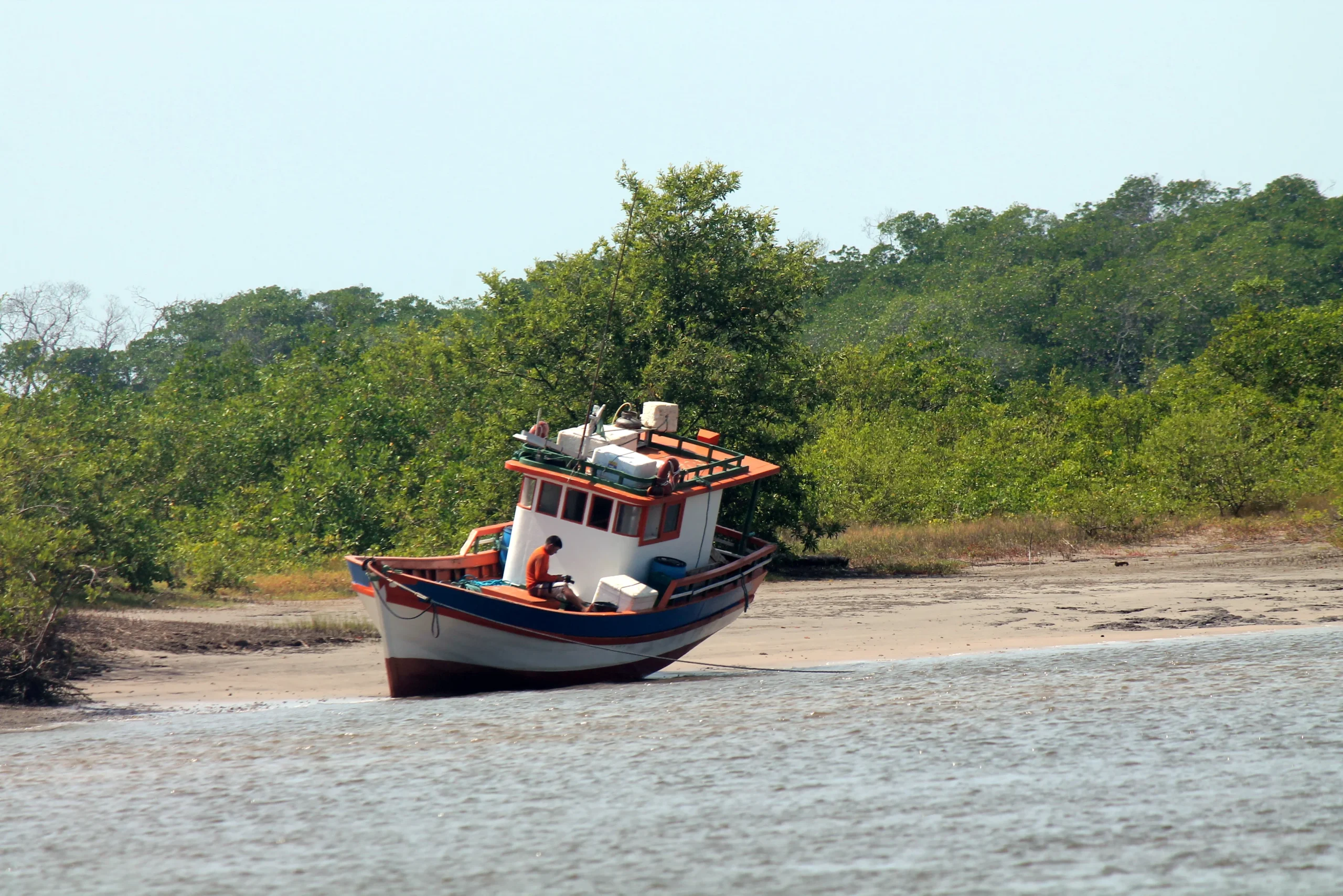 Rio brasileiro e barco tradicional durante o defeso de reproducao das especies aquaticas