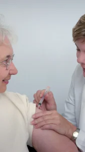 Idosa e cuidadora recebendo assistência e suporte social